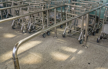 Metal airport luggage carts parked together near entrance