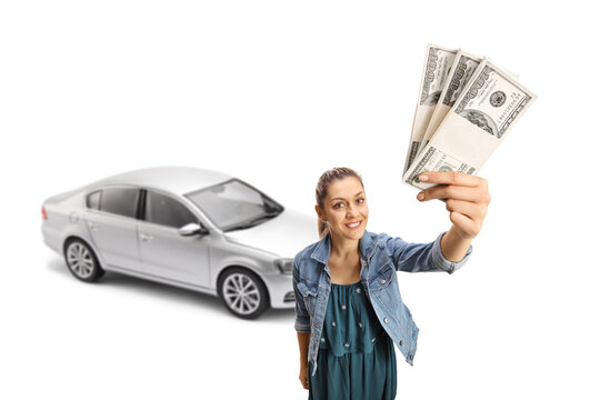 Young woman holding money in frint of a silver car