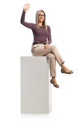 Young professinal woman sitting on a white column and waving