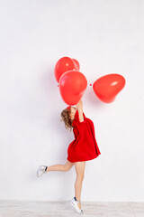 valentine's day kids. Little girl in red dress holding heart shaped balloons