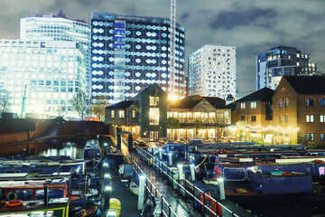 At night, boats are parked in docks. To align with Birmingham's vintage-modern atmosphere, docs are brightly illuminated. Reflection of modern buildings can be seen on calm waterways.