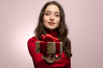 Girl in red with a gift out of focus, joy on her face