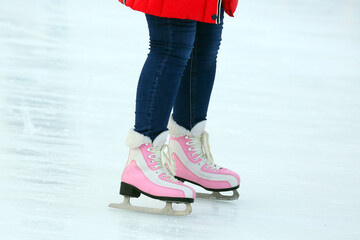 Legs of a woman skating on an ice rink. Hobbies and sports. Vacations and winter activities