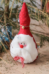 Santa claus soft toy under the Christmas tree with needles crumbling
