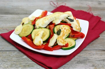 Grilled greek cheese haloumi with vegetables zucchini, pepper, mushroom on white plate