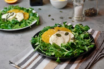 Fresh salad with lettuce, orange, mozzarella and pumpkin seed