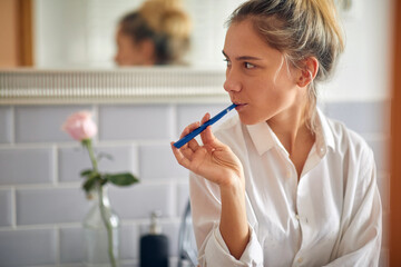 Pretty blond woman brushing teeth