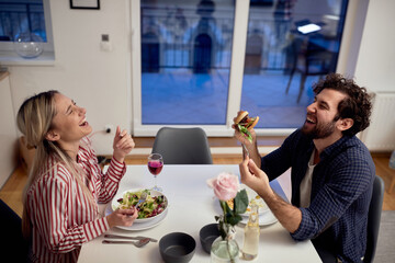 A young couple having a good time while eating together. Home, kitchen, meal, relationship