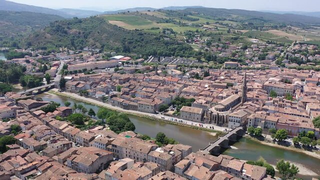 Scenic aerial view of French commune of Limoux on Aude River overlooking gothic spire of Church of Saint Martin in summer, Occitanie
