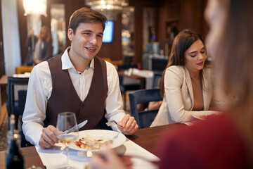 Young people enjoying eating lunch at the restaurant. Business, restaurant, lunch