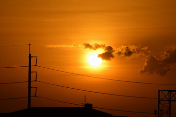 Sunset view Beautiful golden yellow sky in big cities,Power transmission system With the sky and the beautiful clouds in bright days.Golden sunset with poles and power lines