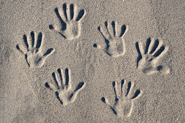 Hand print engraved in sand at the beach