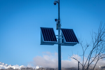 Outdoor security camera with solar panels in the mountains in winter.