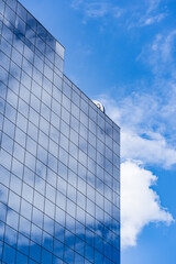Fototapeta premium Modern Glass Building Architecture with blue sky and clouds