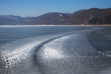 Cincis lake in winter. Hunedoara, Romania. Road on frozen lake in winter. Ice road on like. Road on ice lake