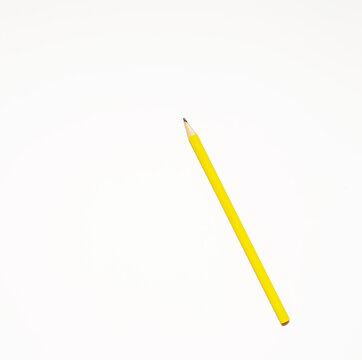 Presentation template with copy space by top view close up macro photo of wooden yellow pencil isolated on white paper that look minimalist and clean. Pencil on paper. Space for text.