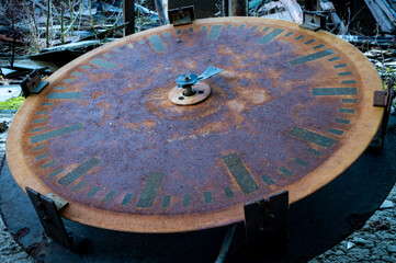 broken and rusted clock on the ground