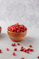 Medicinal plants and herbs. Rose hips berries on concrete background with copy space. Dried fruits for herbal teas and essential oils. Selective focus. Vertical orientation.
