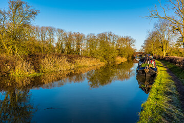 Obraz premium Winter sunshine gives a golden hue to the Grand Union Canal near Foxton Locks, UK