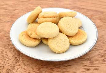 Freshly baked sugar cookies in plate on wooden board