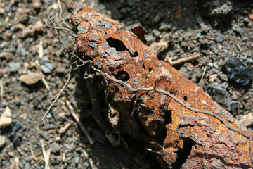 Rusted decaying metal pipe on the ground