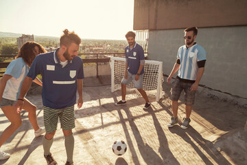 People playing football on building rooftop terrace