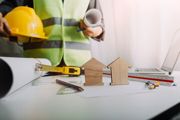 Two colleagues discussing data working and tablet, laptop with on on architectural project at construction site at desk in office