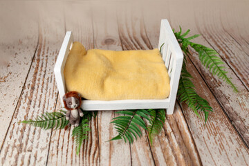 the wooden bed is decorated with a parot. props for a photo shoot of newborns. Toy lion. background for a photo shoot. furniture for dolls