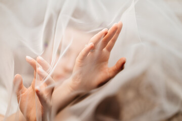 hands of the bride under the veil. Tenderness. 
