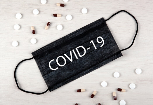 medical mask with the inscription covid-19 and medications