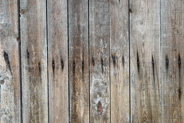 Fence from boards. Texture of a wooden fence. Old dark boards, heads of rusty nails. Rain-soaked boards for photomontage and collage.