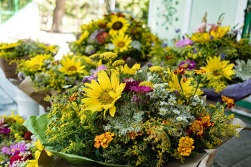 Bouquet of bright yellow sunflowers and wild flowers, close up