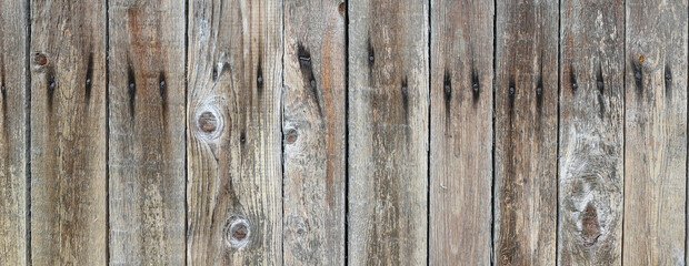 Fence from boards. Texture of a wooden fence. Old dark boards, heads of rusty nails. Rain-soaked boards for photomontage and collage.