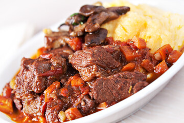 Delicious beef stew with mushrooms and polenta. High quality photo