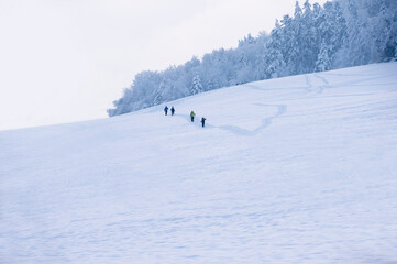 Wintersportler, Schneeschuhwanderer und Spaziergänger laufen durch eine sehr verschneite...