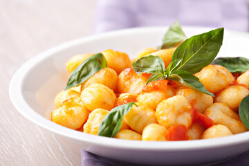 Homemade gnocchi with tomato sauce basil and cheese.