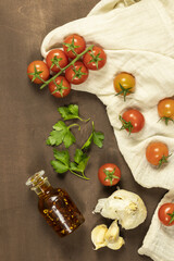 food with Italian ingredients. cherry tomato, red hot chili pepper, olive oil, parsley on wood background.