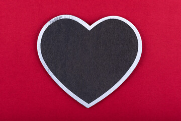 Obraz premium Black chalkboard with heart shape on red background. free copy space. Concept valentine's day. Concept mother's day