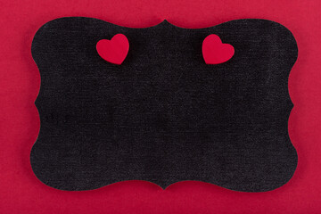 Black chalkboard on red background and two red hearts with space for text.
Concept valentine's day. Concept mother's day. 