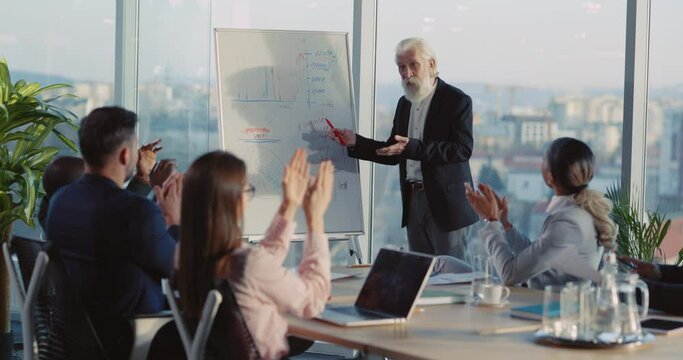 Successful Old Businessman Presenting wonderful Financial Strategy Project Management Making People Applaud in Corporate Office Staff Room.