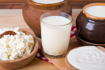Milk in various dishes on the old wooden table. village dairy products