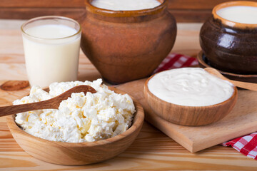 Milk in various dishes on the old wooden table. village dairy products