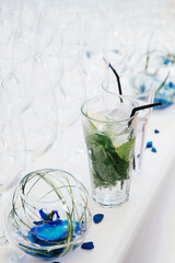 a delicious fresh drink of water with lime and mint stands on a table with a white tablecloth