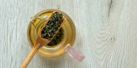 Top view dry tea leaves in a wooden spoon, background.