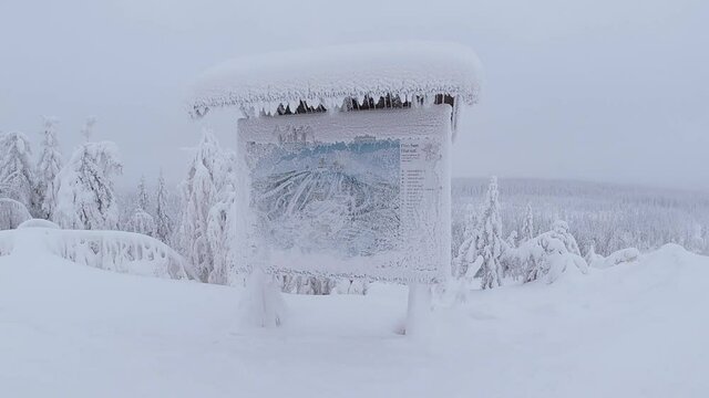 Ground angle of snow flakes falling on a frosty slope map standing on the top of a swedish ski resort. slow-mo video.