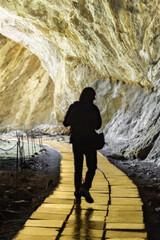 The man saw a golden bright the road how to get out of the cave and goes towards the sun. Silhouette. Concept psychology find your way in life.
