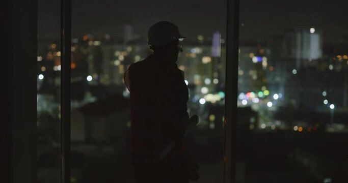 Male Silhouette of Industrial Professional Worker Observing Modern Cityscapewith Already Built Skyscrapers. Manufacture Industry. Night time.