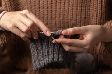 woman hands knitting wool yarn with knitting needles	