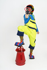 The clown firefighter holds a fire barrel in his hands, extinguishes the fire.