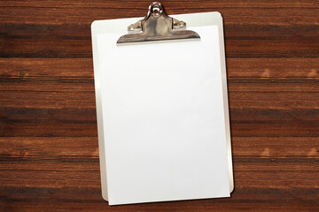 Classic metal clipboard with blank white paper on wood table